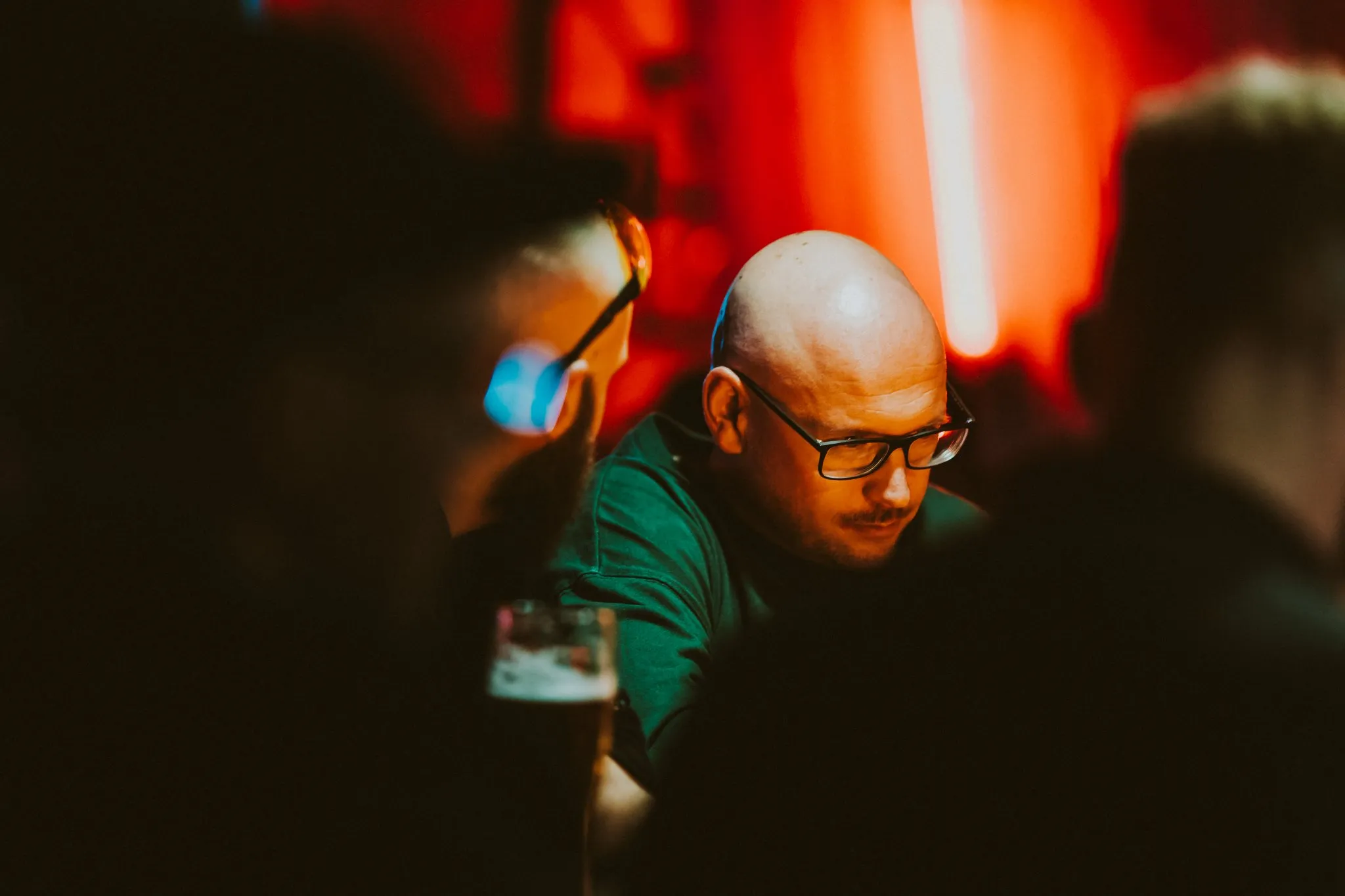 People at the bar of FOMO club in red light