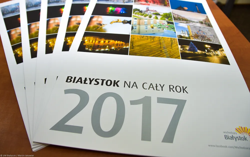 Copies of the “Białystok na cały rok 2017” wall calendar spread out on a table